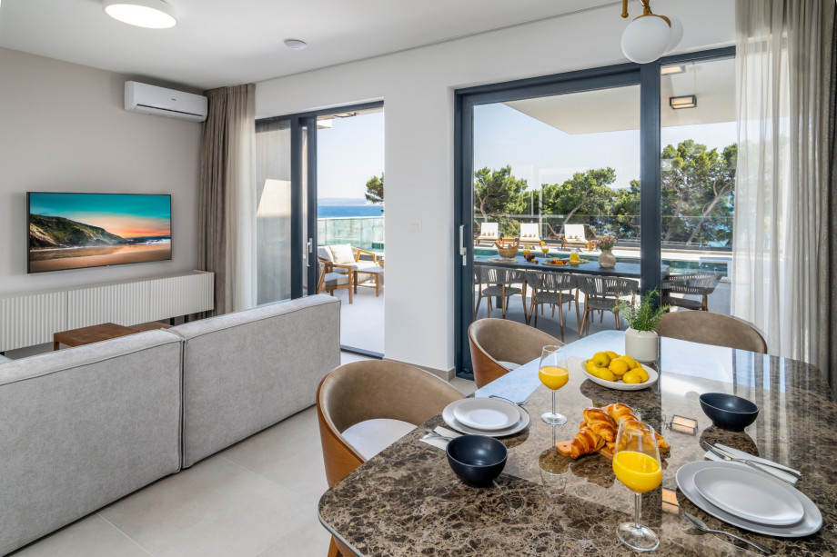 Dining area with a glass door toward the pool area and direct exit to the covered outdoor dining area