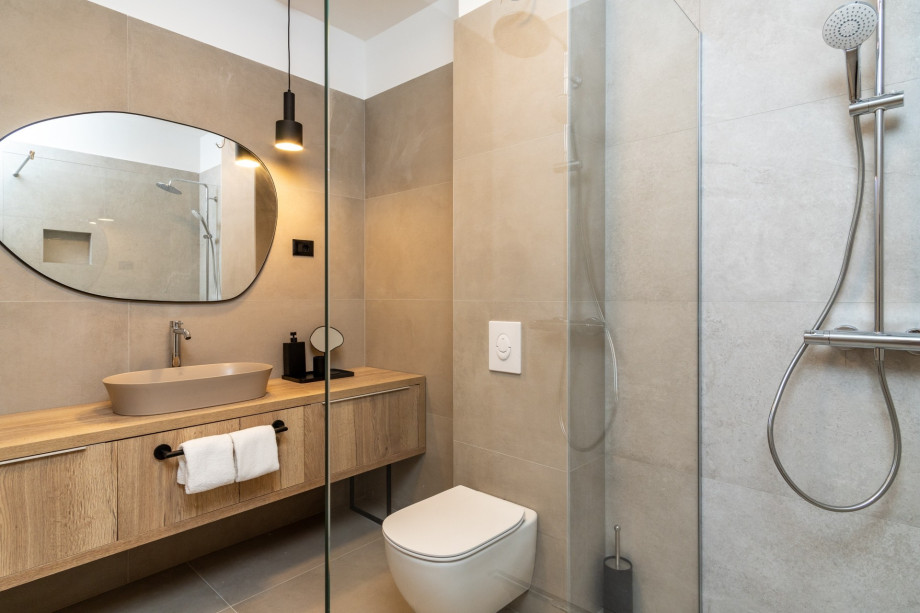 An en-suite bathroom with a shower, a sink, and a toilet