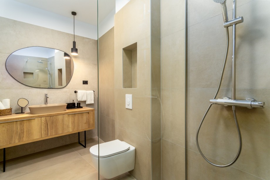 An en-suite bathroom with a shower, a sink, and a toilet