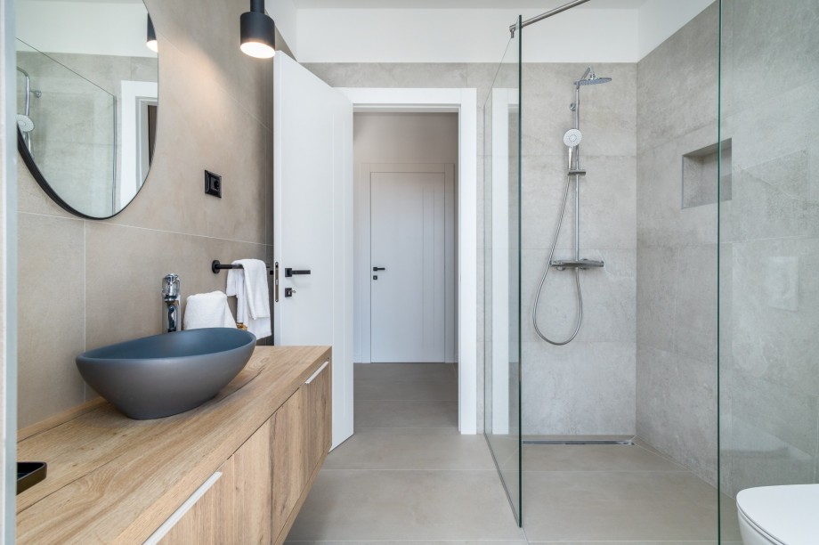 An en-suite bathroom with a shower, a sink, and a toilet
