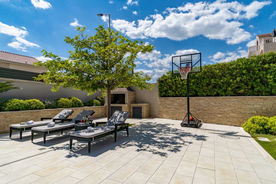 8 comfortable lounge chairs in the natural shadow, next to the outdoor dining area