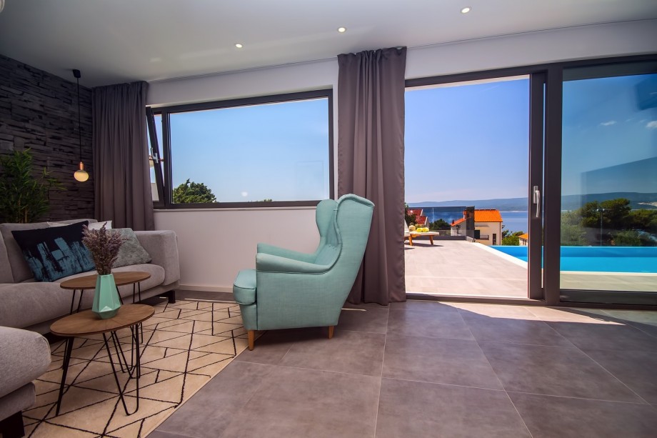 Living room connected with kitchen and dining area, exit to the pool