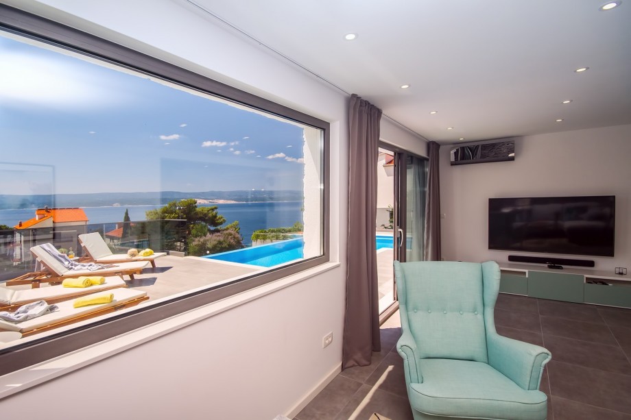 Living room connected with kitchen and dining area, exit to the pool