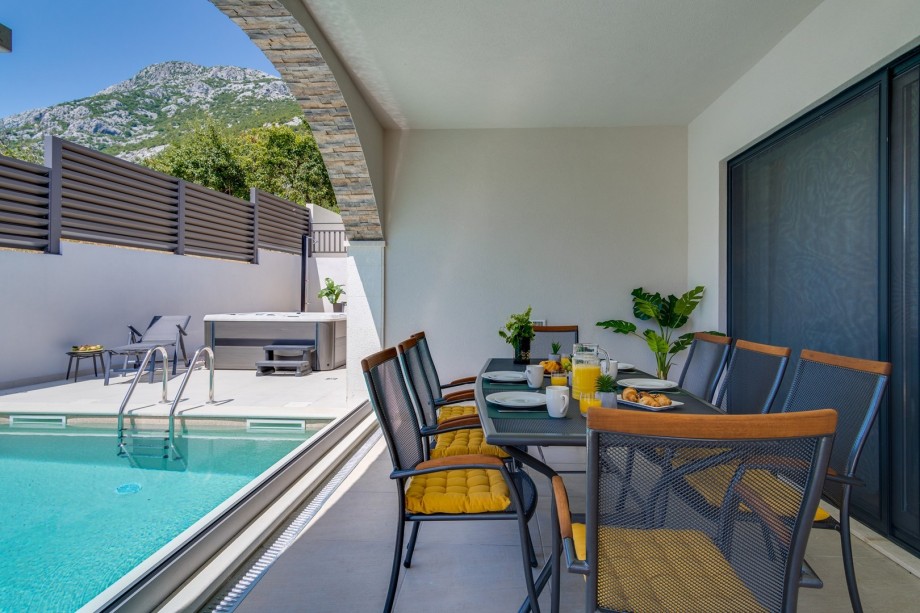A covered outdoor dining area for 8 people (with a direct approach to the indoor kitchen) with a gas grill