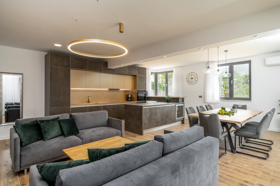 A spacious living area with sofas and a flat-screen TV, A/C, free WiFi