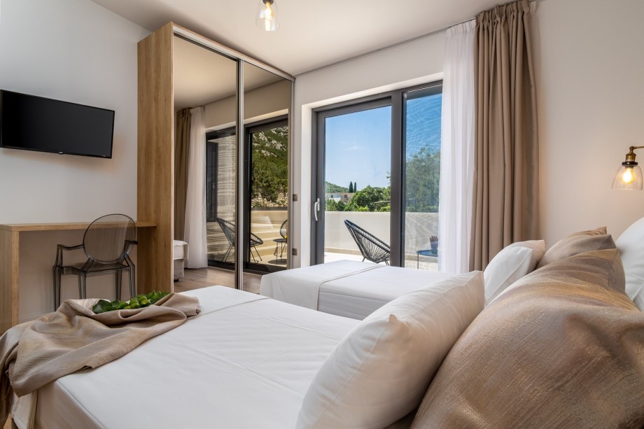 Bedroom No3 offers an en-suite bathroom, a TV, an A/C, and an exit to the terrace with a lounge corner