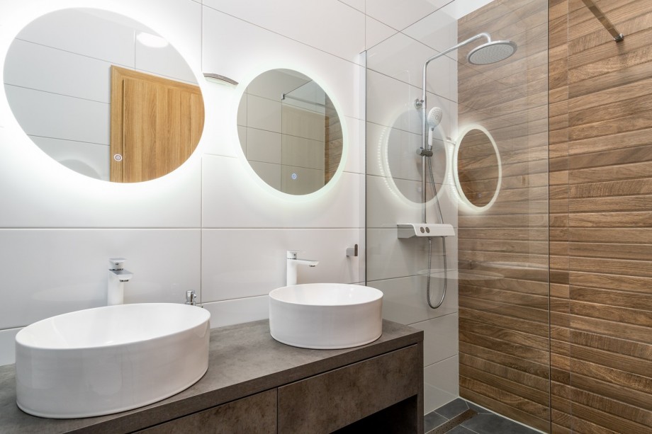 An en-suite bathroom with a shower, a double sink, and a toilet