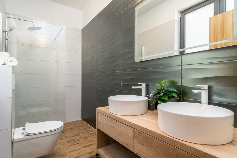 An en-suite bathroom with a shower, a double sink, and a toilet