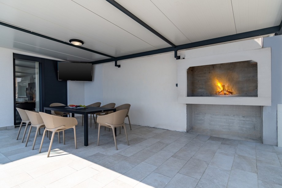 An outdoor dining area for 8, and a traditional barbecue next to it