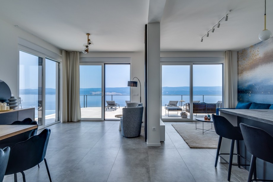 Ground floor offers a spacious living area with flat screen TV, A/C, WiFi, floor-to-ceiling doors toward the pool area