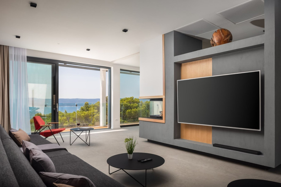 The living area of this light and airy space offers a flat-screen TV, a PS4, a fireplace, two comfortable sofas (can open into the sofabed), and a balcony with sea views