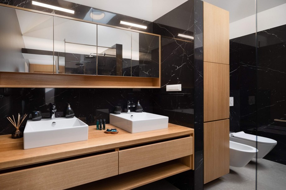 An en-suite bathroom with a bathtub and a shower, a double sink, a toilet, and a bidet