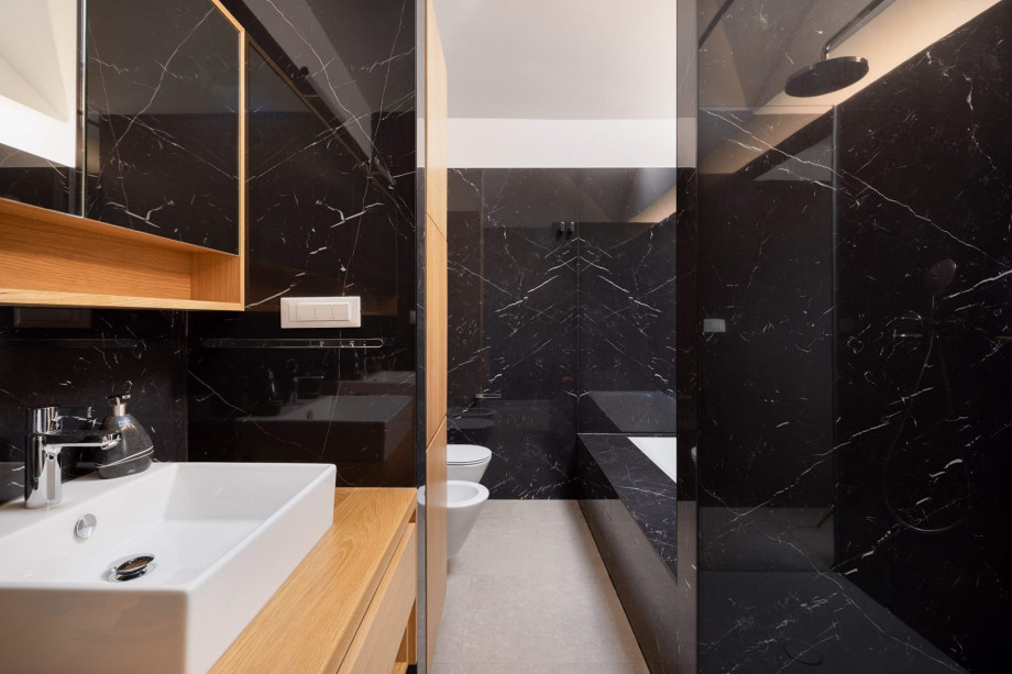 An en-suite bathroom with a bathtub and a shower, a double sink, a toilet, and a bidet