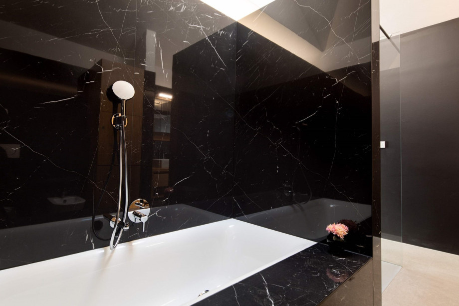 An en-suite bathroom with a bathtub and a shower, a double sink, a toilet, and a bidet