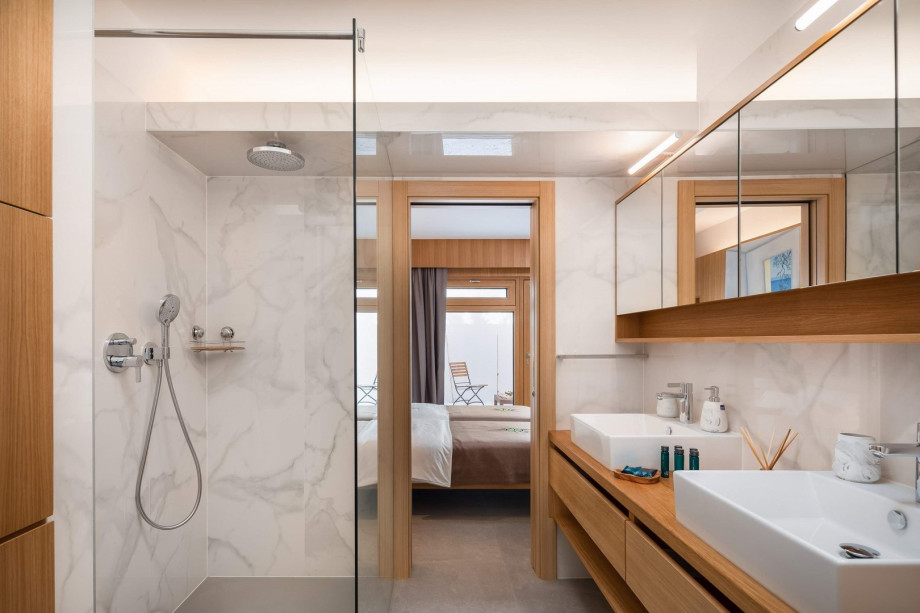An en-suite bathroom with a shower, a double sink, a toilet, and a bidet