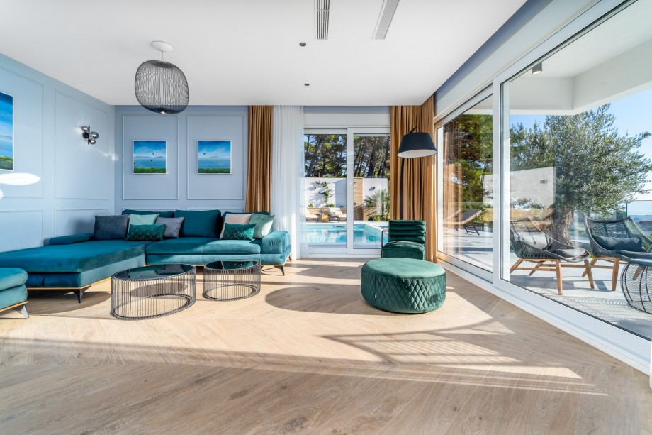 A very comfortable living area with glass walls and direct approach toward the pool area.