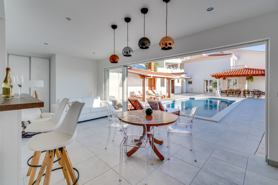 Modern summer kitchen and lounge area next to the pool