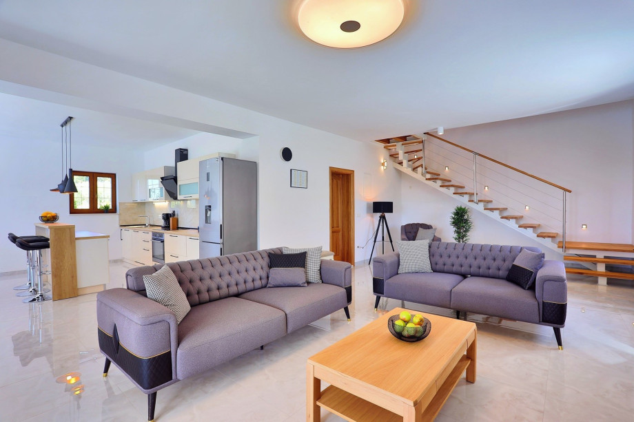 Living area with sofas, a smart TV, Finish sauna with a shower next to it, a separate toilet, and dining area with a Fully equipped kitchen