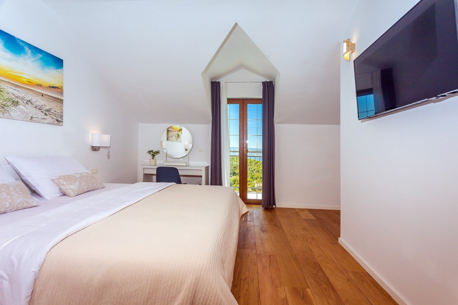 Bedroom No4 with a king size bed 180x200cm, en-suite bathroom with a shower, a TV, A/C and a balcony with a pool view.