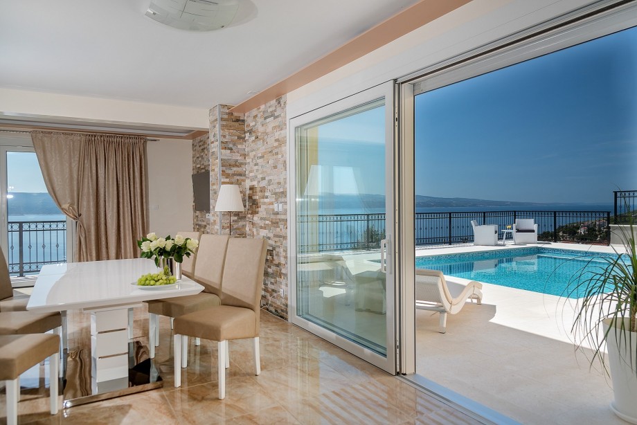 The first floor (pool level) offers an open concept living and dining room with a fully equipped kitchen