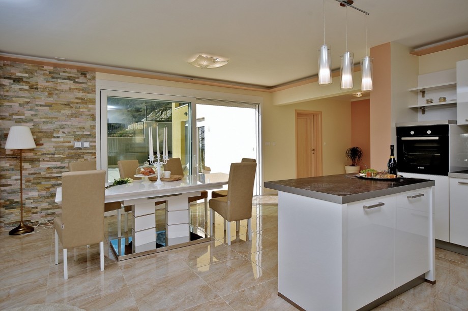 From the living and dining room, you have two direct exits toward the pool and a terrace with sea views.