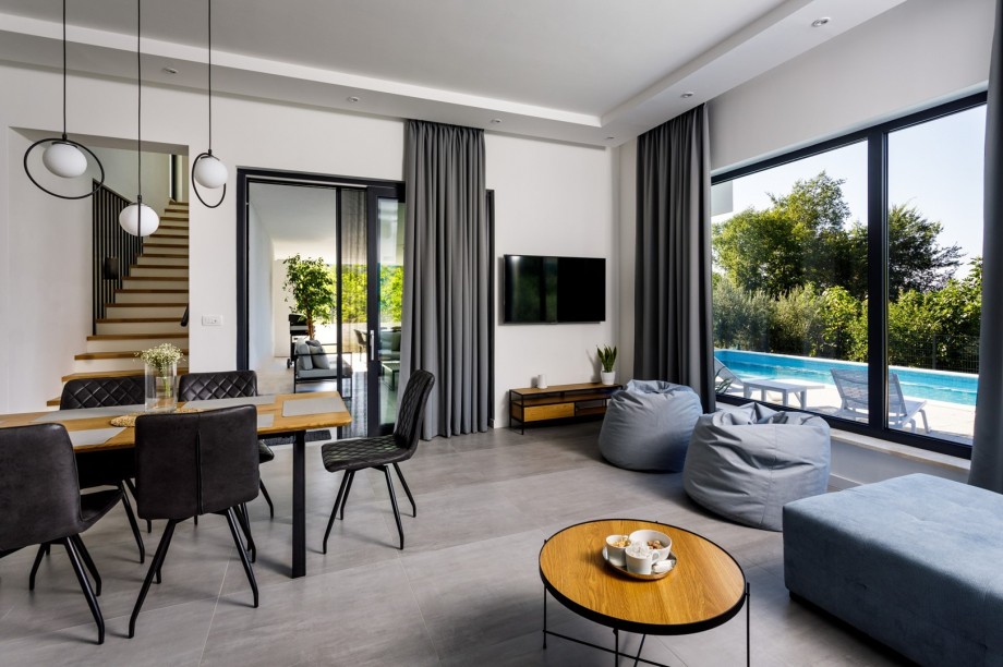 The ground floor offers a spacious living room with flat screen TV with Netflix and IPTV, air conditioner, free WiFi, comfy sofa and two lazy bags with glass walls toward the pool area.