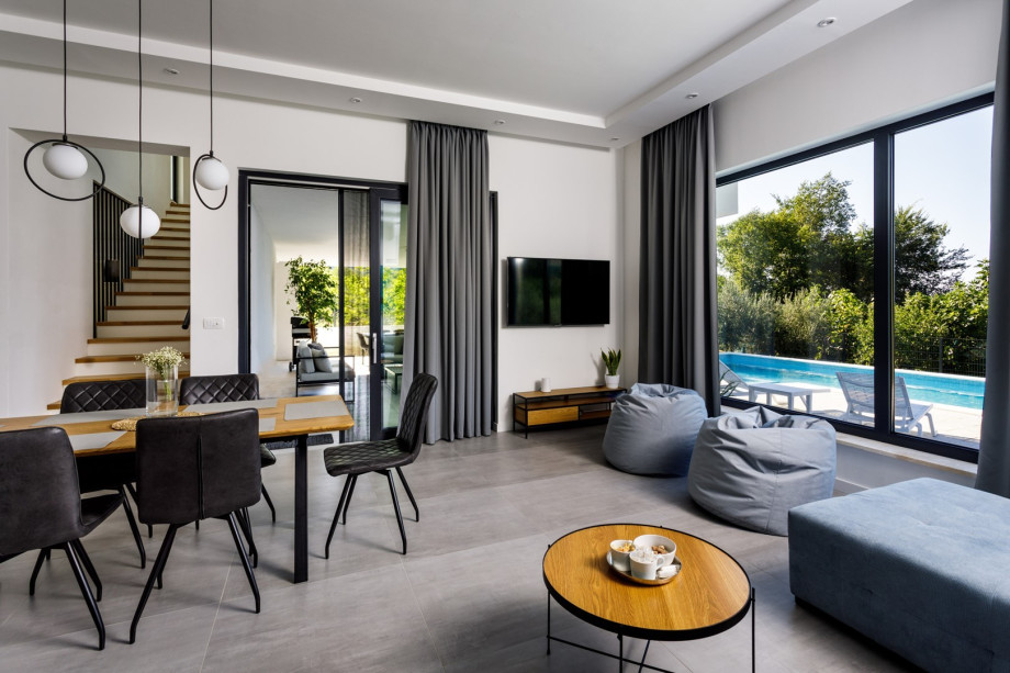 The ground floor offers a spacious living room with flat screen TV with Netflix and IPTV, air conditioner, free WiFi, comfy sofa and two lazy bags with glass walls toward the pool area.