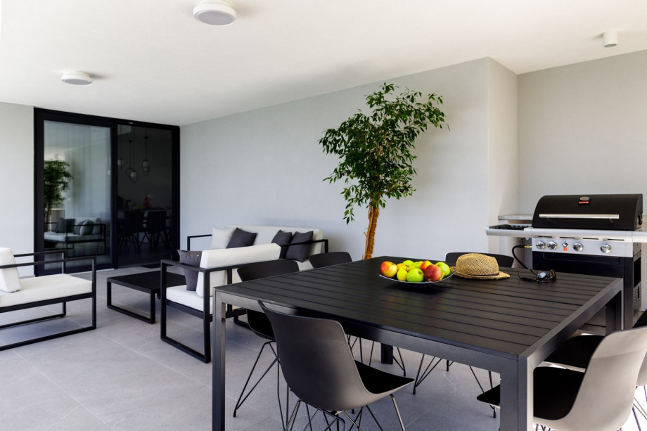 There is a covered terrace with a lounge corner, a dining area with a barbecue (gas) and a table tennis.