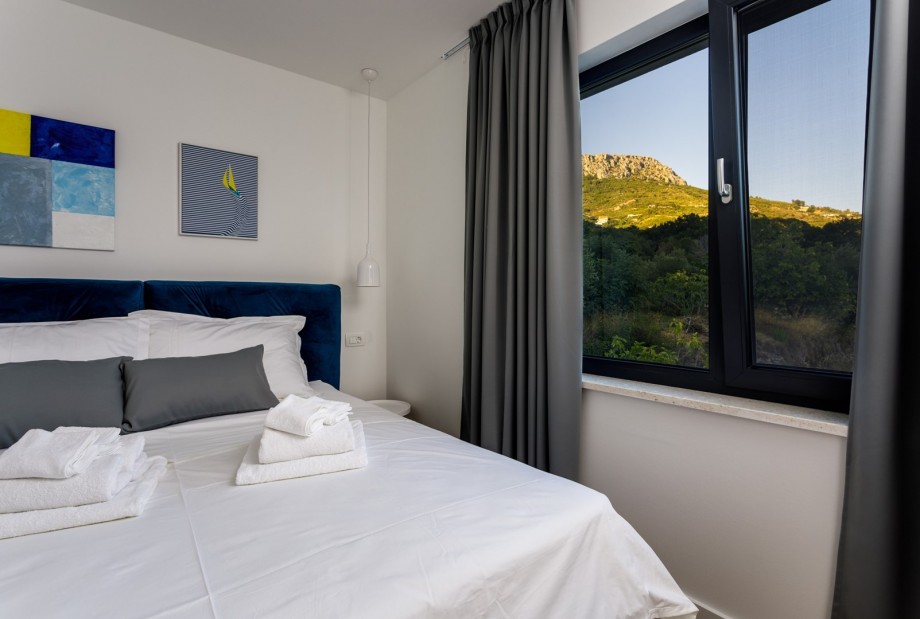 Bedroom No1 with a king size bed 180cm x 200cm, air conditioner, a TV and views on hills.