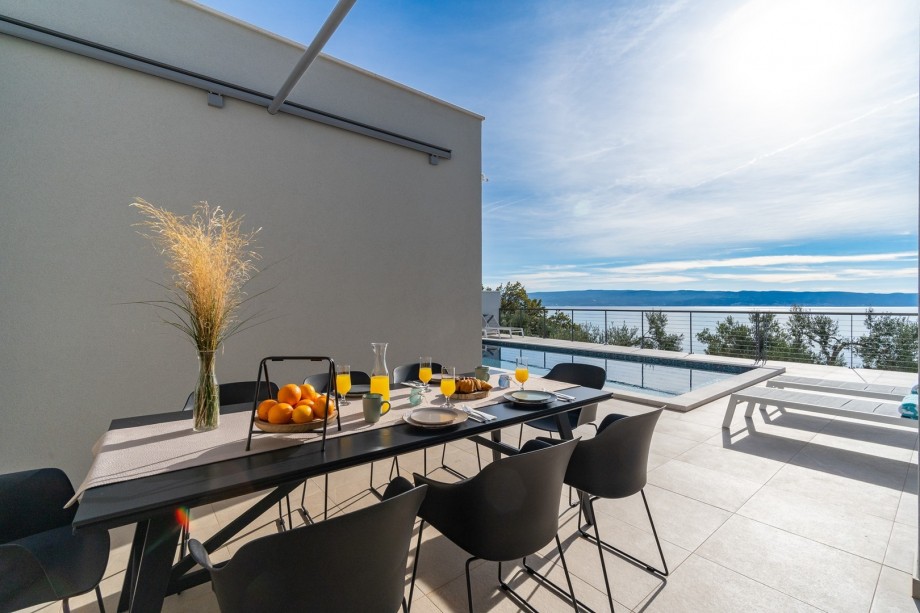A covered outdoor dining area with a barbecue (direct approach to the kitchen and living room)