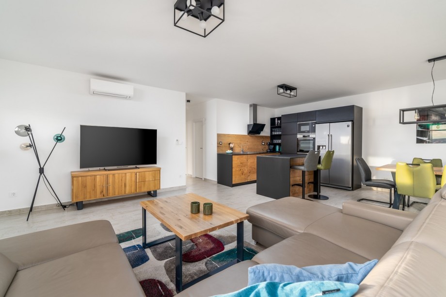 A living room with a flat-screen TV, A/C, comfortable sofa (ground floor)