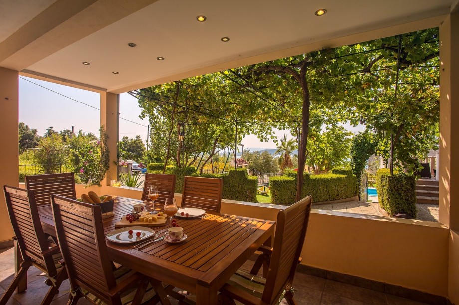 Covered outdoor with dining area for 14 people a few steps from the pool