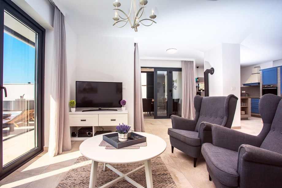 Tastefully furnished living area with exit to pool and outdoor dining area