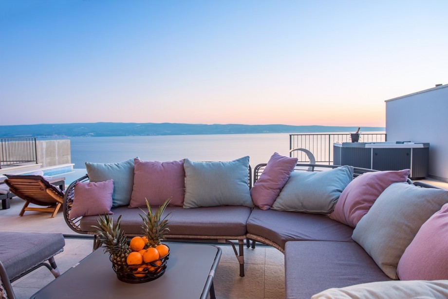 Covered outdoor lounge corner next to outdroor dining table