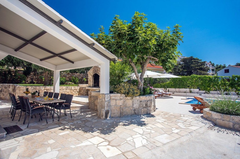 Outdoor dining area next to the grill and pool, direct exit from the kitchen