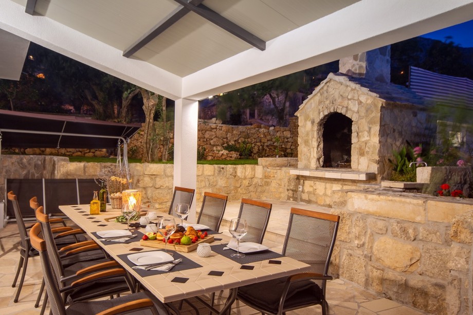 Outdoor dining area and grill in the evening