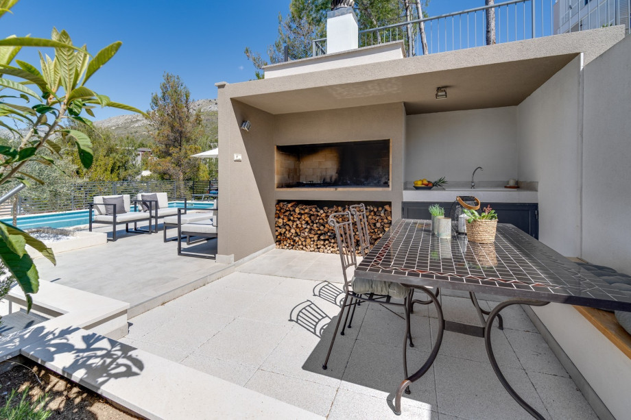 An outdoor dining area with a barbecue and a lounge corner for nice evenings
