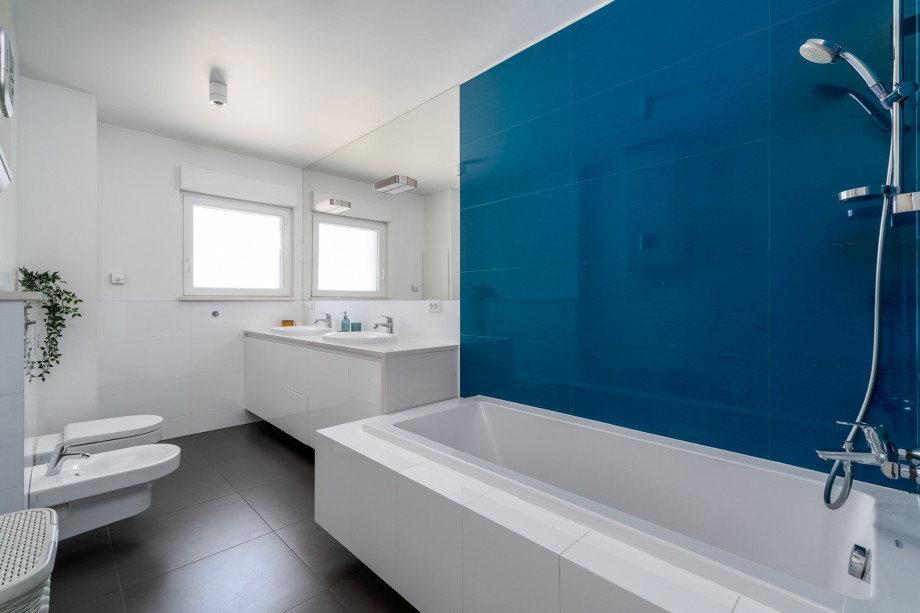A Family bathroom with a bathtub, two sinks and a bidet