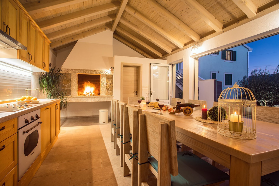 Fully equipped kitchen with dining area and toilet with view on the pool area