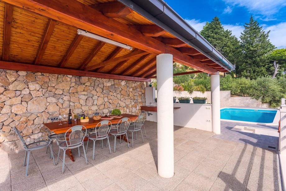 Spacious outdoor dining area with wooden playhouse - next to the pool area