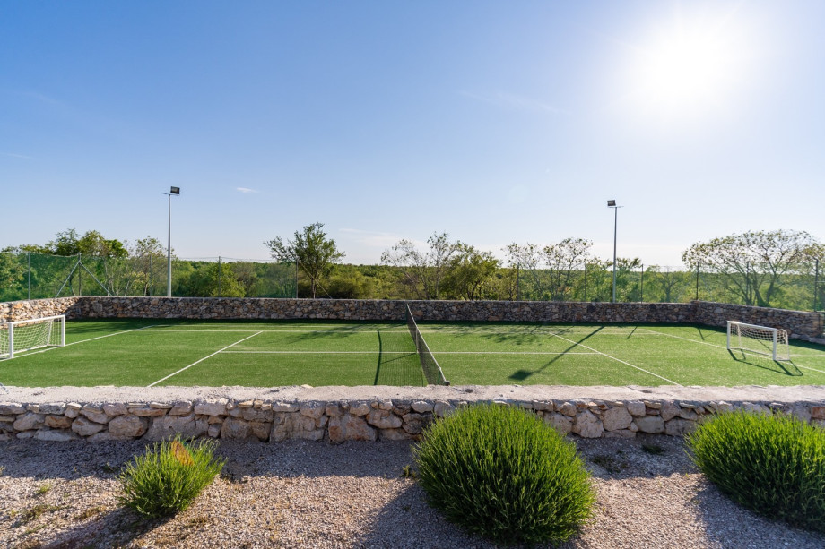 A  fenced Tennis court with artificial grass and 4 rackets, if preferred can also be used as football field