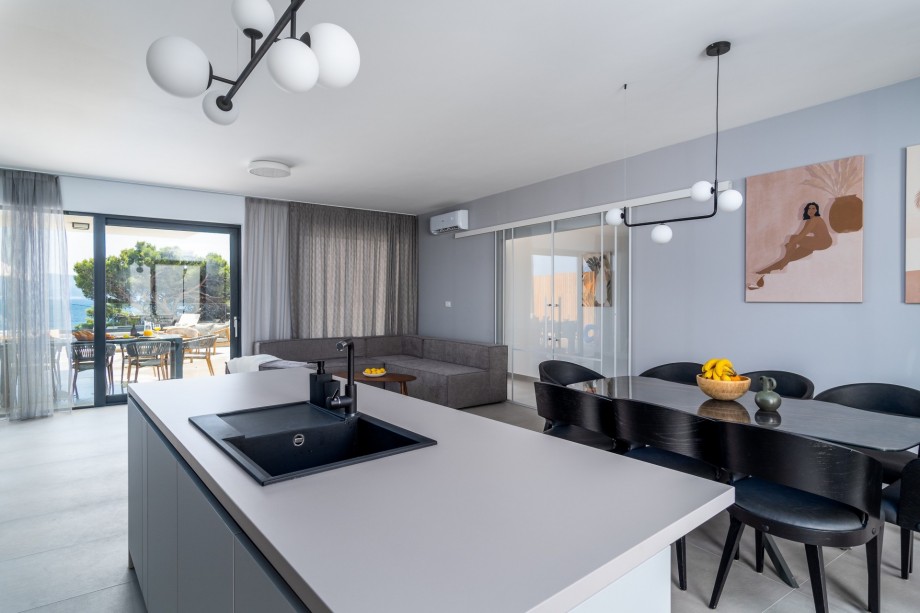A dining area with a glass door toward the pool area and direct exit to the covered outdoor dining area