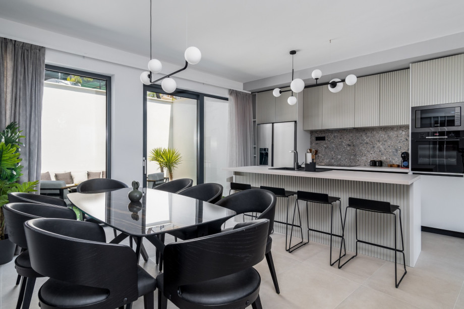 A fully equipped kitchen with a kitchen island and all of the required appliances