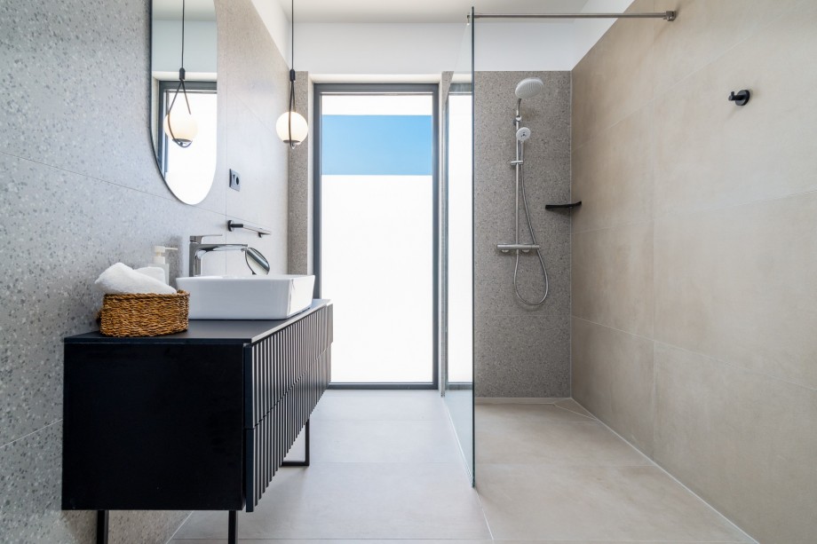 An en-suite bathroom with a shower, a sink, and a toilet