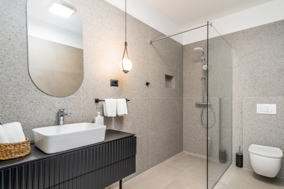 An en-suite bathroom with a shower, a sink, and a toilet