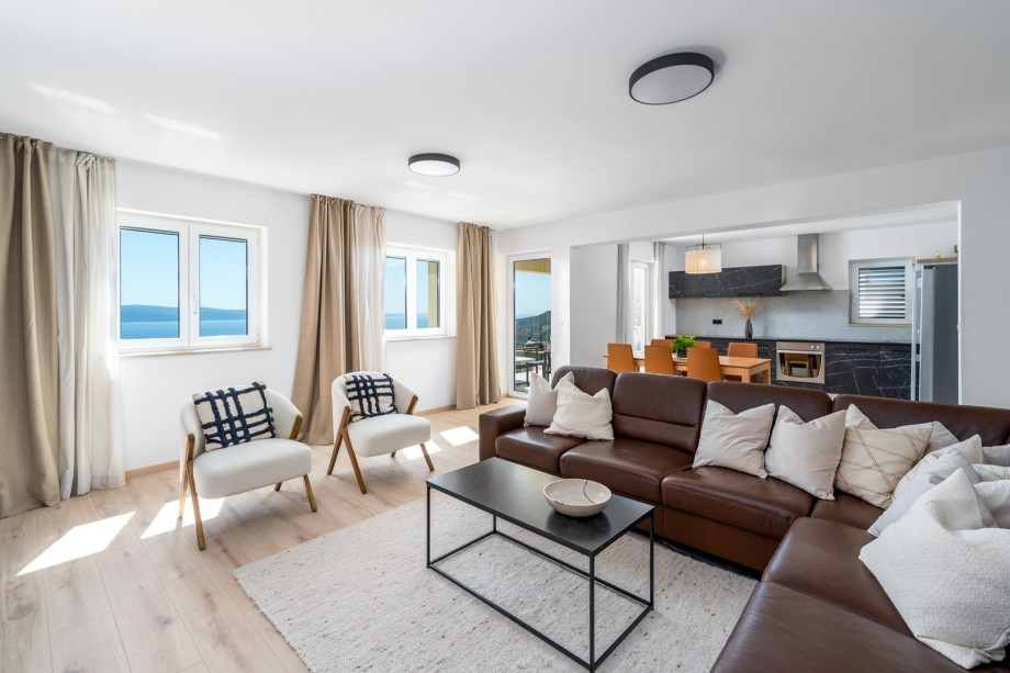 Dining area with exit to the lounge corner and a dining terrace with grill, Family bathroom with a shower, toilet and a bidet, and another smaller family bathroom with a shower and a toilet