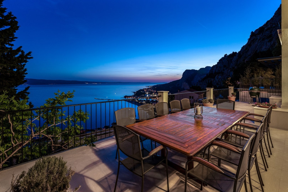 Large wooden dining table for 12 people and a Kamado Joe grill, with panoramic sea views giving you a really nice feeling while enjoying al-fresco