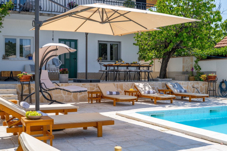 A fully fenced sun deck area with 6 deck chairs and two lounge corners