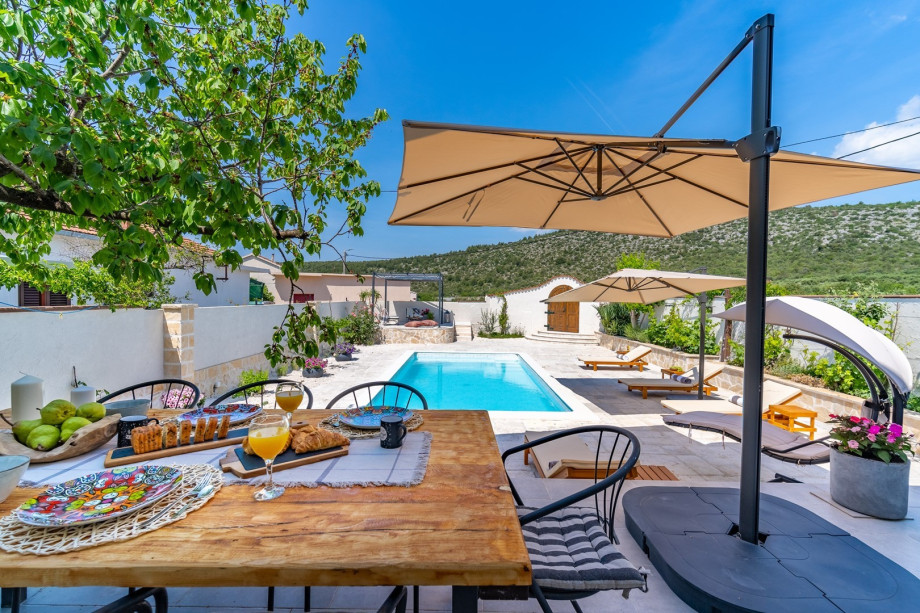 A covered outdoor dining area for 8 people, and outdoor shower