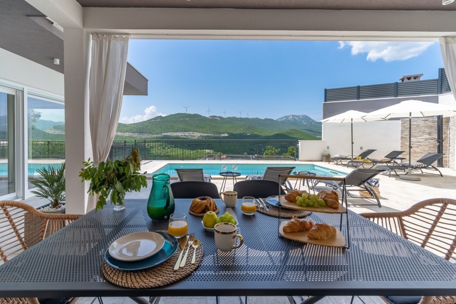 The outdoor area offers a covered outdoor dining area with a TV and the traditional barbecue, and a cozy swing